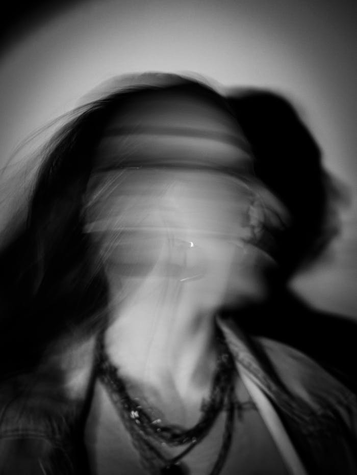 Dynamic black and white portrait of a woman in motion, creating a blurred effect.